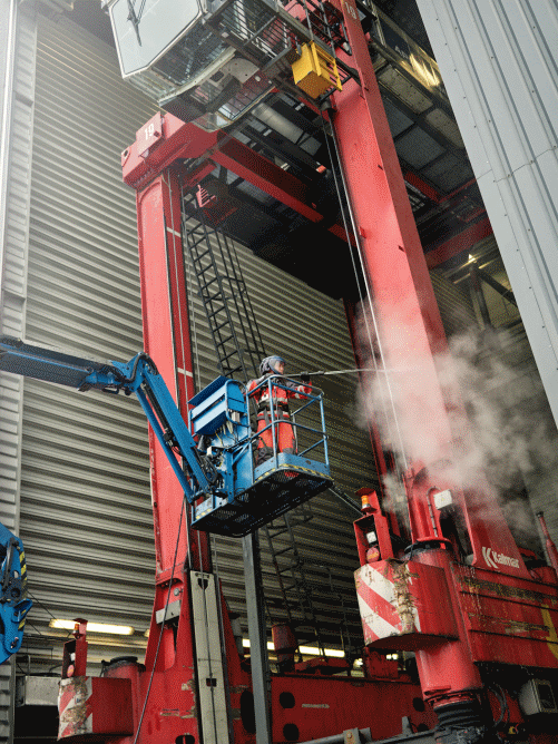a man clean industrial elevator using high pressure washing cleaning equipments